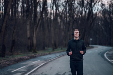 Redhead young man running outside on a mountain road