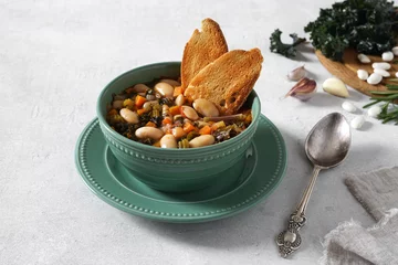 Fotobehang Homemade Ribollita, tuscan bean soup with light rye ciabatta in green bowl © Taborisova