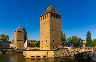 Fototapeta na wymiar Scenic summer view from Vauban Dam of Petite France quarter, covered bridges and watchtowers on River Ill in city of Strasbourg in France..