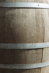 Germany. Heidelberg Castle. Fragment of an old wooden vine barrel with an metall hoop on a dark background. Wooden barrel with metall straps. Wood texture. Side view. Close-up. Macro. Copy space