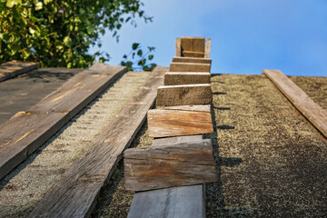 Wooden stairway to the sky. Wooden staircase on the roof of the house. Homemade wooden staircase.