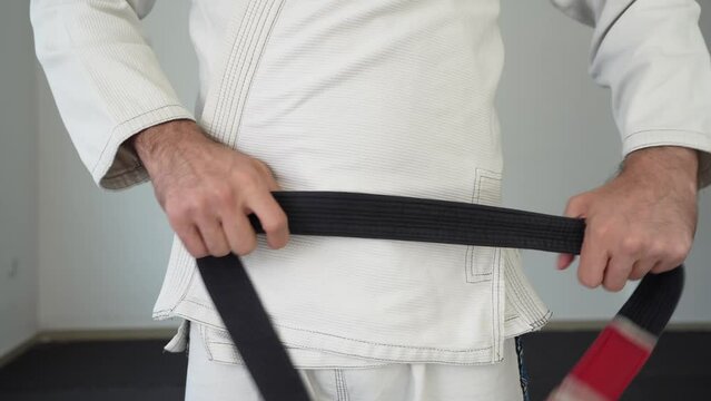 unknown man tie bjj brazilian jiu jitsu black belt around the waist