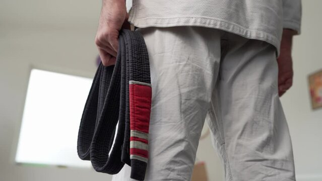 unknown caucasian man hold brazilian jiu jitsu bjj black belt
