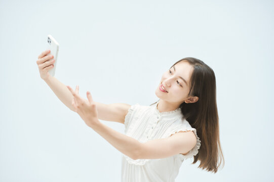 スマートフォンを持ちながら舞う若い女性