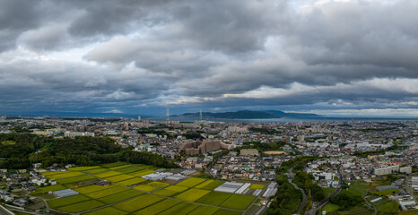 Dramatic typhoon clouds over rice fields at edge of town