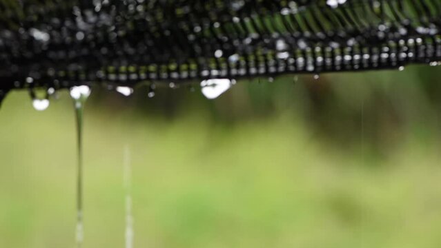 Raindrops are dripping at the bottom of the rain cover in a heavy rain atmosphere,abstract blurry background
