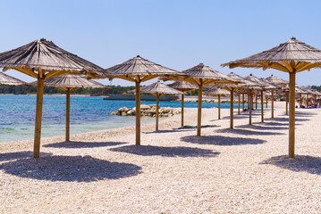 straw umbrellas on the beach. Empty beaches during quarantine. luxury beach. Pandemic warning, lack of tourists