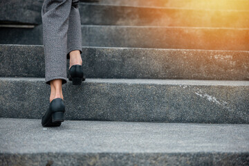 Stepping going up stairs in city, Closeup legs of businesswoman hurry up walking on stairway, rush hour to work in office a hurry in morning, foot of business woman wear black shoes step up success - obrazy, fototapety, plakaty