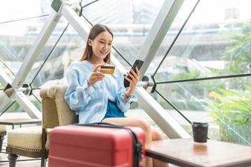 Young asian beautiful female lady making a payment for an online shopping purchase via her smart...