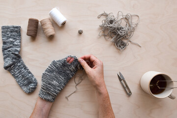 Woman's hands mending hole in a sock