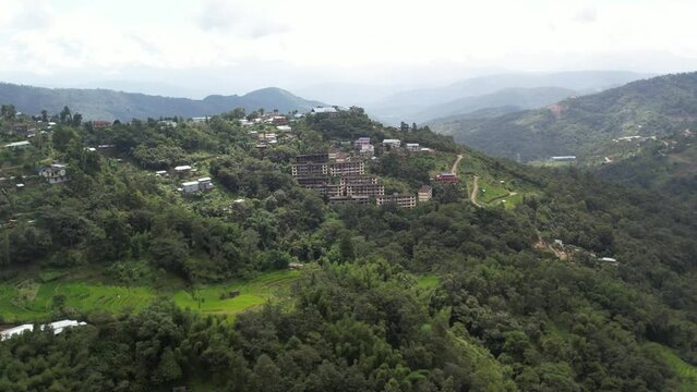 Drone shot of buildings surrounded by trees and forest on hills in Kohima, Nagaland India