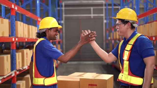 Two Asian warehouse worker touching a hands together.