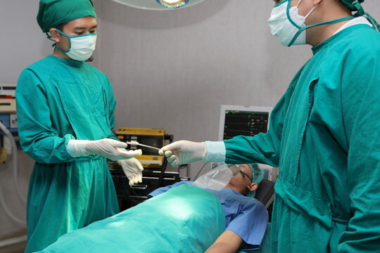 Closeup image of professional hands concentrated surgical team performing an operation with patient in hospital operating room