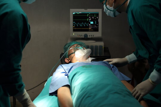 Closeup image of professional concentrated surgical team performing an operation with patient in hospital operating room. Surgery concept.