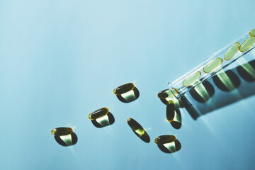 Capsules of omega-3 fatty acids on a blue background in a flask. The concept of medicine and a healthy lifestyle. Front view.