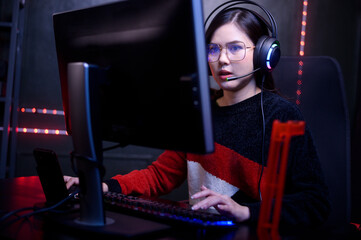 Young female professional Streamer and gamer with headset playing online video games