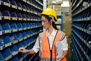 Portrait Asian women staff worker Standing counting and inspecting products in the warehouse.