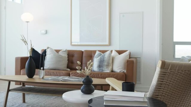 Knee level rising shot of the living area in a high ceiling penthouse condominium unit focus from close to far during a sunny day