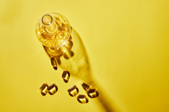 Omega-3 fatty acid capsules on a blue background in a flask. The concept of medicine and healthy living. Front view.