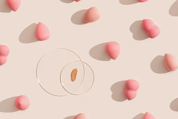 Makeup sponges for foundation cream, samples on glass disk on beige color background with shadows. Skincare beauty blender. Flat lay swatches from tone cream and sponge, minimal aesthetic
