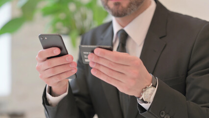 Middle Aged Businessman using Smartphone and Laptop