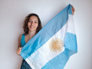 Argentina soccer fan young woman smiling and holding flag on white background