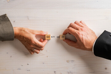 Hands of male and female business people assembling a Dont quit Do it sign