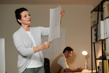 Pensive Serious Engineer with Floor Plan