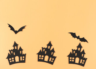 Fototapeta na wymiar decorations for Halloween holiday, castles and bats on orange background with copy space.