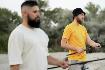 Profile Portrait of two bearded fishermen friends fishing in the summer, close-up. Active leisure and hobby