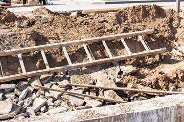 Wooden ladder lies on a construction site. Safety precautions for high-altitude work in construction.