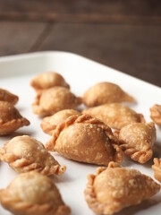 golden brown deep fried mini curry puff on white tray