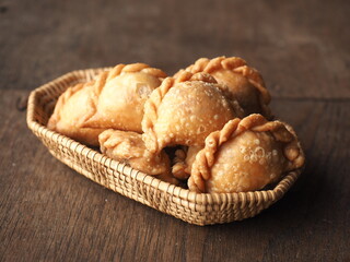 golden brown deep fried mini spiral curry puff pastry in basket