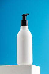 Mockup of a white dispenser with a cosmetic product with a place for your logo on a podium.