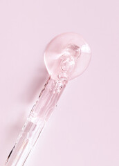 pipette serum closeup on a light pink background