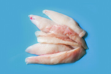 Monk fish fillets on blue ocean color surface. Seafood product with fine taste and soft tender feel. Fish monger craft.