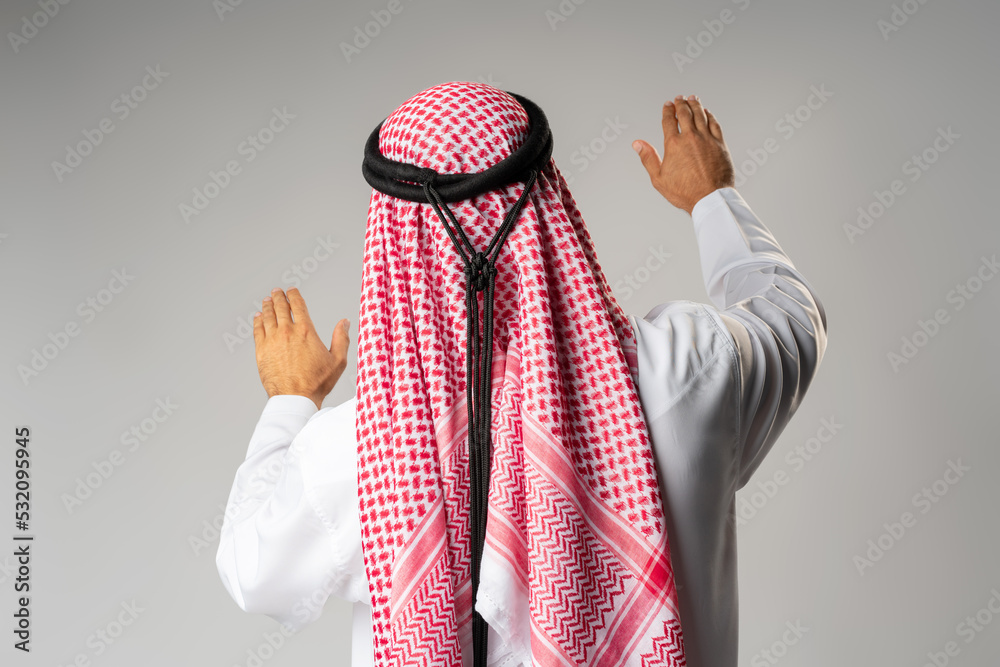 Canvas Prints Back view of young Arab man standing on gray background