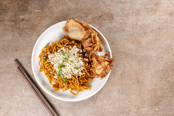 Mie Goreng ala Mie Gacoan is homemade fried noodle topping with chicken shraded and fried dumpling.