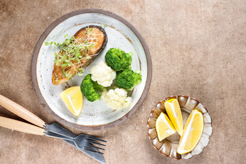 Fried salmon steaks with lemon butter sauce garnish with micro greens.