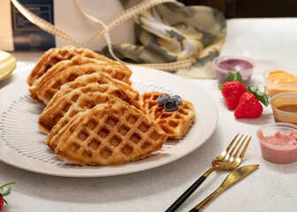 Croissant Waffle or its fa,mous names Croffle on white plate with white background. Served with various dipping sauce. Selective Focus