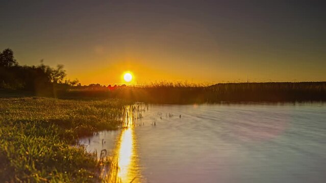 Shot of high tide to low tide with the view of sun setting in the background in timelapse.