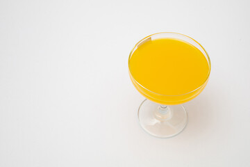 Orange juice in wine glass on white background
