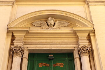 Santa Lucia del Gonfalone Church Facade Close Up with Entrance and Sculpted Angel Head and Wings in Rome, Italy