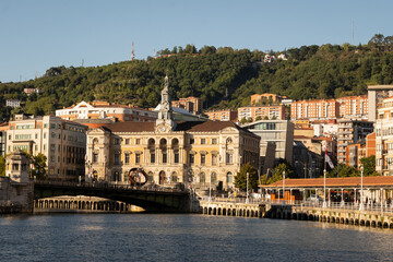 Fototapeta na wymiar A view of the town hall in Bilbao and the bridge Puente del Ayuntamiento crossing over the estuary river nervion