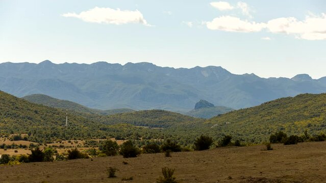 Time lapse shot of the steppe with grass and bushes near Komic with Velebit mountains in the background