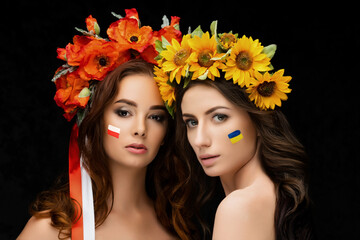 Two beautiful girls in flower wreaths of red poppy and yellow sunflower with ribbons. Concept...