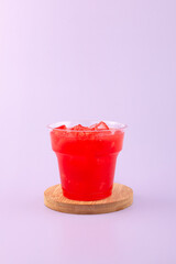 Jus semangka drink in disposable plastic take away cup. Fresh iced Smoothie made from watermelon and melon pulp. Melon and Watermelon fresh juice with ice cubes