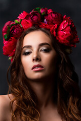 Naklejka premium Beautiful Ukrainian woman in a colorful wreath of pink and burgundy peony. Girl's headdress. Sensual portrait