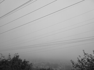 panorama nebbia in bianco e nero, i fili disegnano tagli nel cielo.