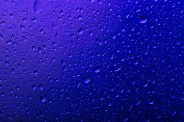 The texture of a water drop on a blue background close-up.